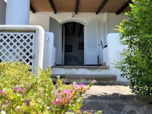una puerta blanca de una casa con flores rosas en Casa Surya - Sea view terrace, Isola Salina, en Malfa