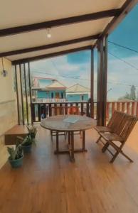 a patio with a table and a bench on a deck at Guest house Cemara in Pasuruan