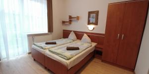 a bedroom with a bed and a cabinet in it at RIWIERA Dźwirzyno in Dźwirzyno +53 photos