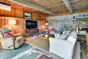 een woonkamer met 2 stoelen en een open haard bij Cozy Cohocton Cottage with Private Beach and Deck! in Cohocton