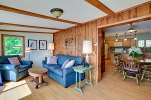 Cozy Cohocton Cottage with Private Beach and Deck! في Cohocton: غرفة معيشة مع أريكة زرقاء وطاولة