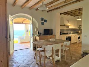 una cocina con mesa y sillas y el océano en Casa Surya - Sea view terrace, Isola Salina, en Malfa