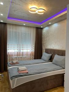 ein Schlafzimmer mit einem großen Bett mit violetter Beleuchtung in der Unterkunft Apartman Branković Pirot-Zapadni Kej 58 in Pirot