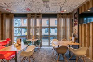 ein Restaurant mit Tischen und Stühlen und einem großen Fenster in der Unterkunft ibis De Panne in De Panne