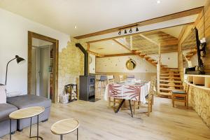 a living room with a table and a couch at Le Ptit Bonheur - avec vue montagne et terrasse in La Bresse