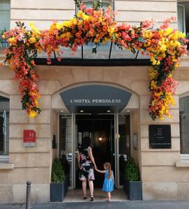 a woman and a little girl standing in front of a building at Le Pergolèse Paris Champs Elysées in Paris