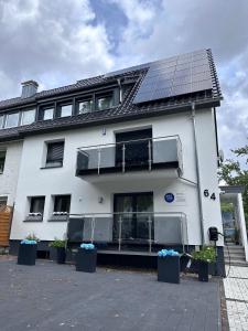 un edificio bianco con pannelli solari sul tetto di FeWo by HD mit Parkplatz, Wallbox, Wintergarten a Bad Salzuflen