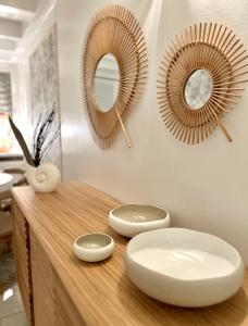 a counter with two mirrors and two bowls on it at Bungalow Sucrier, les pieds dans l'eau in Terre-de-Haut