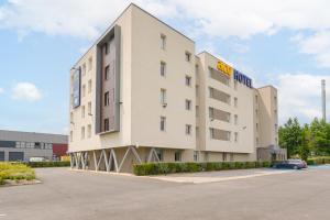 un bâtiment avec un panneau d'hôtel sur son côté dans l'établissement Ace Hôtel Paris Roissy, à Mitry-Mory