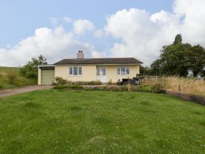a house with a grassy yard in front of it at Palace Bungalow in Hereford