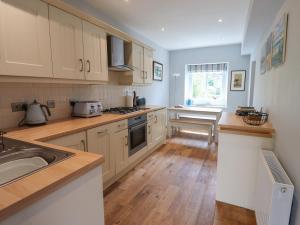 a kitchen with a sink and a stove top oven at Alnside Cottage in Alnmouth