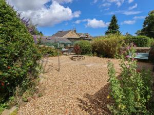 a garden with a gravel path and flowers at Alnside Cottage in Alnmouth