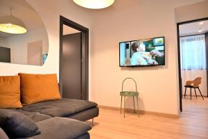ザコパネにあるFerrata Apartamenty Zakopaneのリビングルーム(ソファ、壁掛けテレビ付)