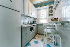 een keuken met blauwe kasten en een kruk erin bij Villa Marilisa in Pula