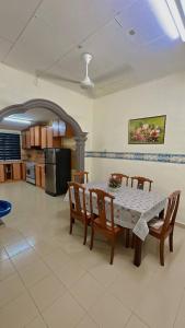 a kitchen with a table and chairs in a room at Mama Ija Homestay Islamic Arau in Arau