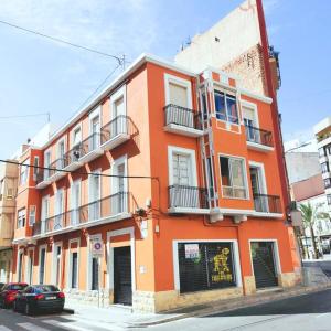 un edificio naranja en la esquina de una calle en Piso 90 m2, centro Alicante (C&D), en Alicante