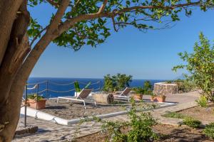 un grupo de sillas sentadas en un patio con vistas al océano en Casa Surya - Sea view terrace, Isola Salina, en Malfa