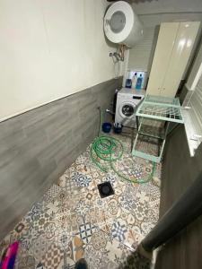 a bathroom with a tiled floor with a washing machine at Piso amplio completo en Almería para 9 personas in Almería