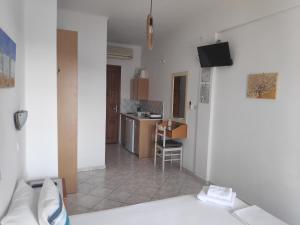 a living room and kitchen with a couch and a television at Villa Dora Studios in Batsi