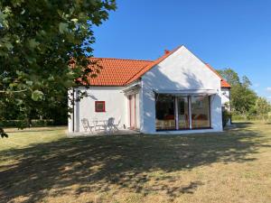 une maison blanche avec un toit rouge dans l'établissement Fogelbergs EsE, à Tofta