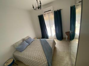 1 dormitorio con 1 cama y cortinas azules en Magnifique et paisible T2 en Marsella
