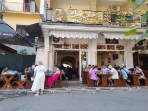 a group of people sitting at tables outside of a restaurant at Ulpiana - Apartments,Rooms,Hostel in Ulcinj