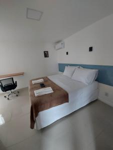 1 dormitorio con 1 cama con escritorio y silla en Audaar Tech Suítes - Aeroporto de Congonhas en São Paulo