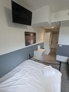 Schlafzimmer mit einem weißen Bett und einem Flachbild-TV in der Unterkunft Hotel-Chao NL 24 hours open in Utrecht