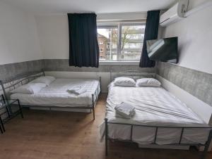 Duas camas num quarto com uma janela em Hotel-Chao NL 24 hours open em Utrecht