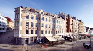 a large white building on the corner of a street at Clarion Collection Hotel Amanda in Haugesund