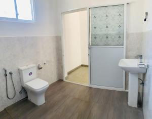 a bathroom with a toilet and a sink and a shower at Kujaku in Arugam Bay