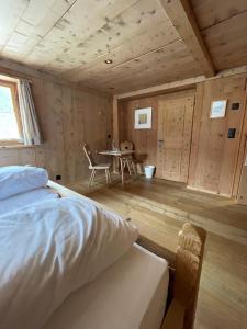 a bedroom with a bed and a table in a cabin at Alpengasthof Crusch Alba ed Alvetern, S-charl in Scuol