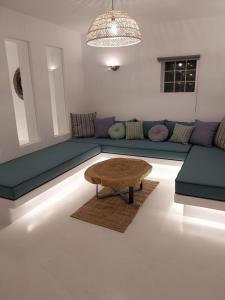 uma sala de estar com um sofá e uma mesa de centro em Altana Boutique Hotel em Tinos