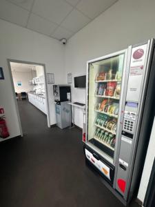 a room with a refrigerator filled with food and drinks at Arena Hostel & Monteurzimmer in Hamburg +36 photos