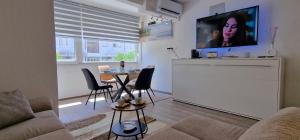 a living room with a couch and a table with chairs at Soft apartment in Solin next to Split in Solin