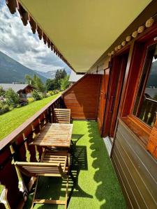 a porch with a wooden table and chairs on a house at Studio au pied des pistes in Châtel