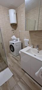 a bathroom with a sink and a washing machine at Soft apartment in Solin next to Split in Solin