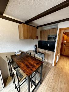 a kitchen with a wooden table with chairs and a microwave at Studio au pied des pistes in Châtel