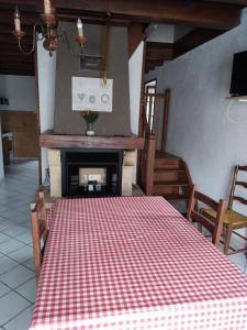 una mesa con un mantel a cuadros rojo y blanco en La petite ferme de Lucie et Andréa, en Saint-Vitte-sur-Briance