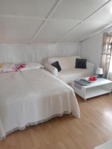 ブワディスワボボにあるwilla MARINA SUNの白いベッドルーム(ベッド1台、ソファ付)