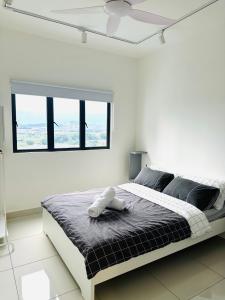 a white bedroom with a large bed with a window at Traders garden c180 in Cheras