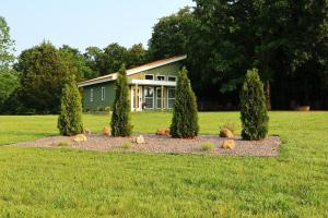 ein Haus mit Bäumen vor einem Feld in der Unterkunft the evergreene in Fredericktown