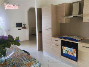una cocina con armarios de madera y una mesa en una habitación en LA FIESTA en Angri