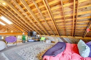 Habitación con cama, TV y techos de madera. en Serene Pacific Getaway Deck, Grill and Fire Pit!, en Pacific