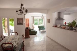 a kitchen and living room with a table and a couch at Le mas dans les Oliviers in Flassans-sur-Issole