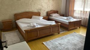 two twin beds in a room with wooden floors at Casa Voronet in Voronet