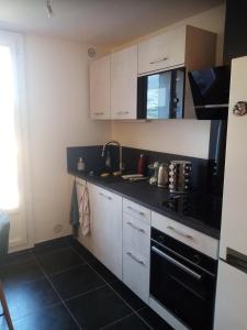 a kitchen with white cabinets and a black stove top oven at Kilian Campus UGA in La Tronche