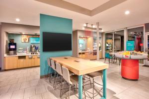 a dining room with a table and a tv at avid hotels - Austin - Tech Ridge, an IHG Hotel in Austin