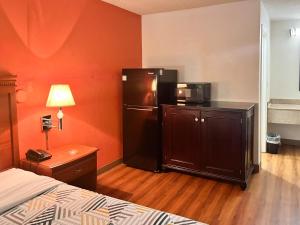 a hotel room with a refrigerator and a bed at Suites Dayton OH Englewood in Dayton