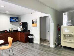 a room with a kitchen with a table and a refrigerator at Suites Dayton OH Englewood in Dayton